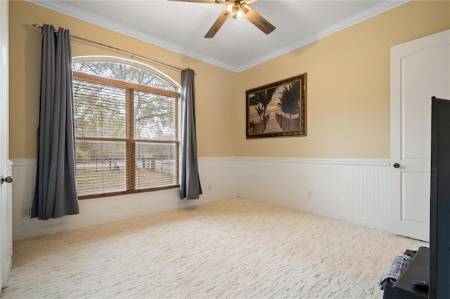 empty room featuring ornamental molding and ceiling fan