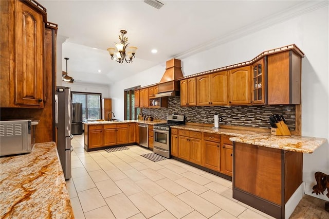 kitchen featuring custom exhaust hood, hanging light fixtures, kitchen peninsula, stainless steel appliances, and light stone countertops