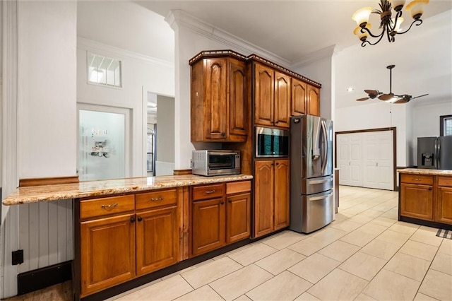 kitchen with light tile patterned flooring, ceiling fan with notable chandelier, ornamental molding, stainless steel appliances, and light stone countertops