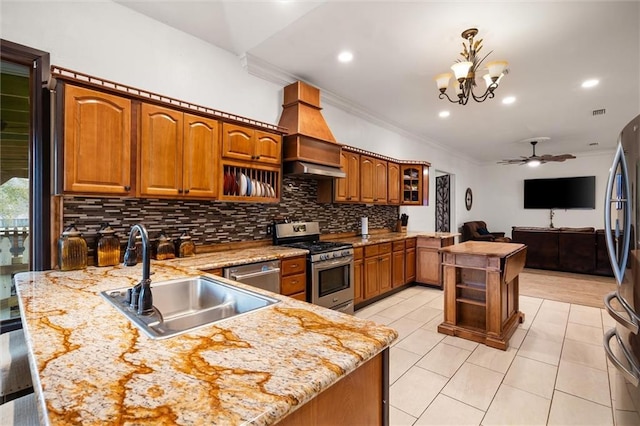 kitchen featuring sink, appliances with stainless steel finishes, ornamental molding, a center island with sink, and decorative light fixtures