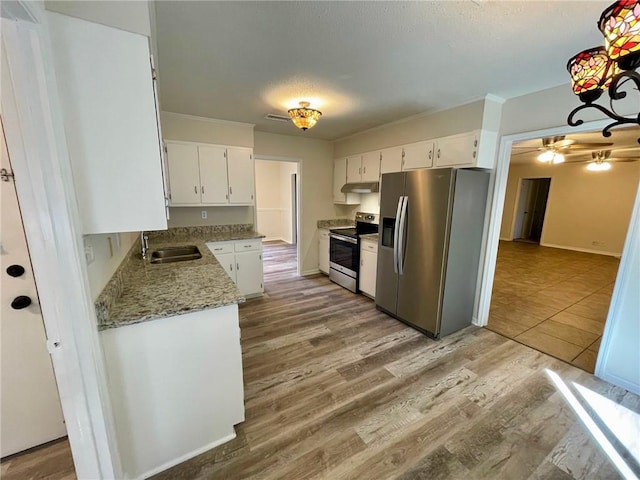 kitchen featuring hardwood / wood-style floors, light stone counters, white cabinetry, stainless steel appliances, and sink