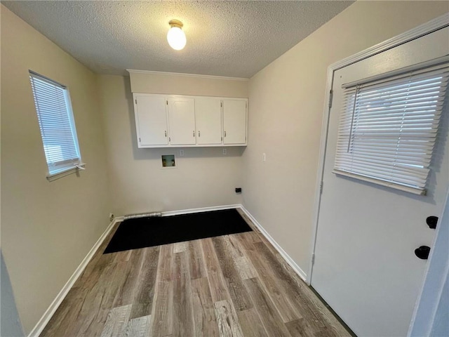 laundry area with a textured ceiling, cabinet space, wood finished floors, and washer hookup