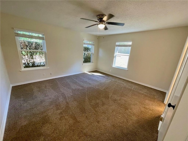 spare room with ceiling fan, a textured ceiling, plenty of natural light, and dark carpet