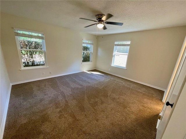 unfurnished room with baseboards, a ceiling fan, a textured ceiling, and dark carpet