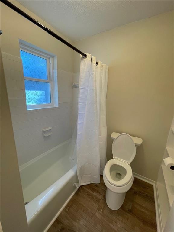 bathroom featuring wood finished floors, shower / bath combination with curtain, and toilet
