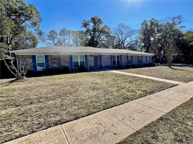 single story home featuring brick siding and a front lawn