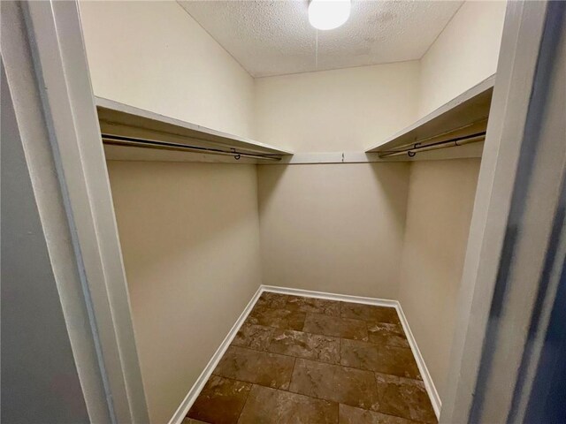 walk in closet with stone finish floor