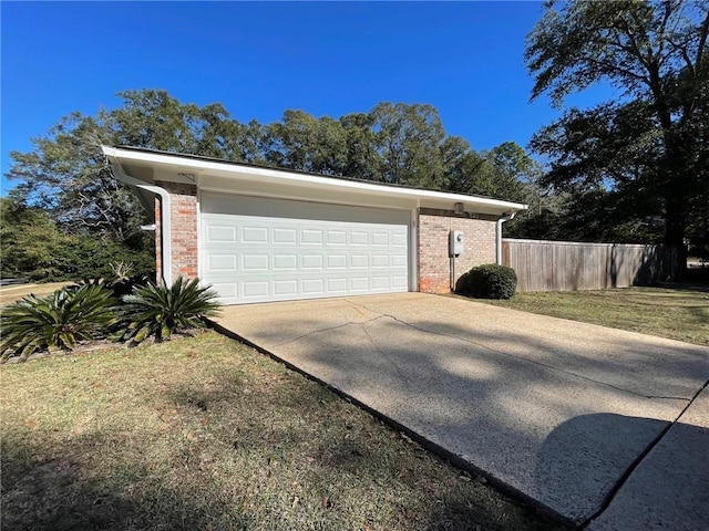 garage featuring fence and concrete driveway