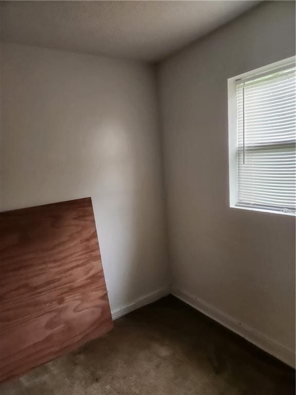 spare room with dark carpet