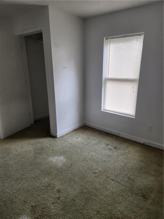 unfurnished room with a textured ceiling and carpet