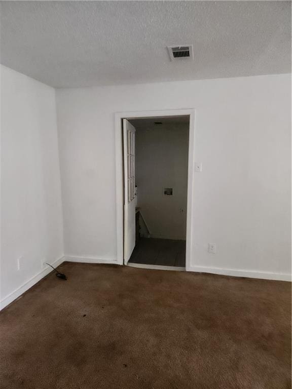 carpeted empty room with a textured ceiling