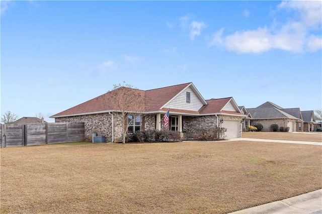 view of front of home with a garage, a front yard, and central air condition unit