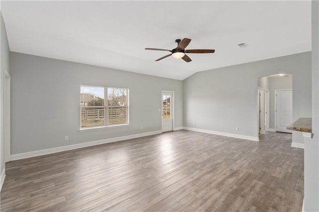 spare room featuring hardwood / wood-style floors, vaulted ceiling, and ceiling fan