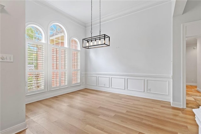 unfurnished dining area featuring light hardwood / wood-style flooring and ornamental molding