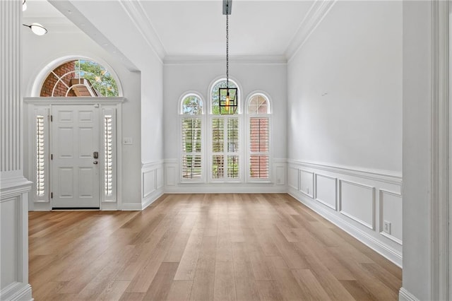 foyer featuring light wood-type flooring and ornamental molding