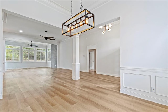 interior space with ceiling fan, decorative columns, crown molding, and light hardwood / wood-style floors