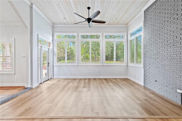 unfurnished sunroom featuring wooden ceiling, ceiling fan, and a wealth of natural light