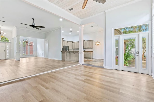 unfurnished living room with light wood-type flooring, ceiling fan, and decorative columns