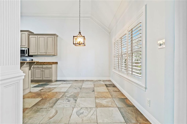 kitchen with hanging light fixtures, lofted ceiling, and ornamental molding