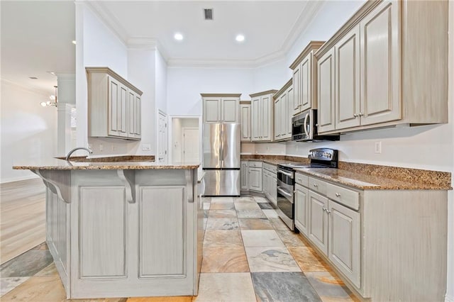 kitchen featuring a kitchen breakfast bar, kitchen peninsula, stainless steel appliances, stone counters, and ornamental molding