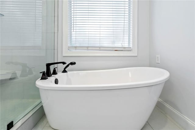 bathroom with a bath and tile patterned floors