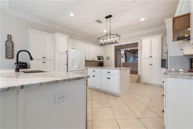 kitchen featuring white cabinetry, white refrigerator with ice dispenser, backsplash, crown molding, and a kitchen island