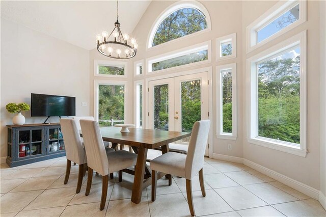 dining space featuring a notable chandelier, light tile patterned flooring, high vaulted ceiling, and french doors