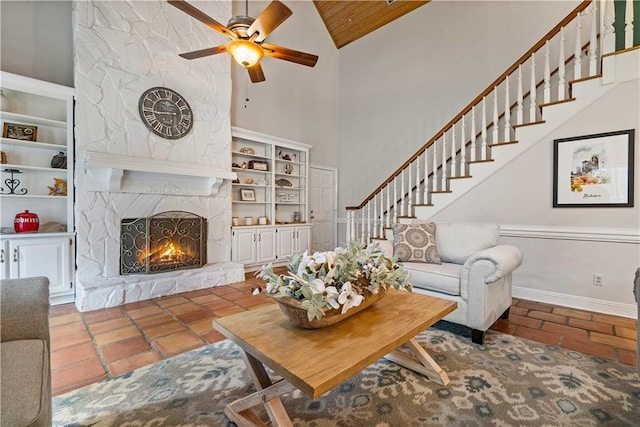 living room featuring wooden ceiling, high vaulted ceiling, tile patterned floors, ceiling fan, and a fireplace