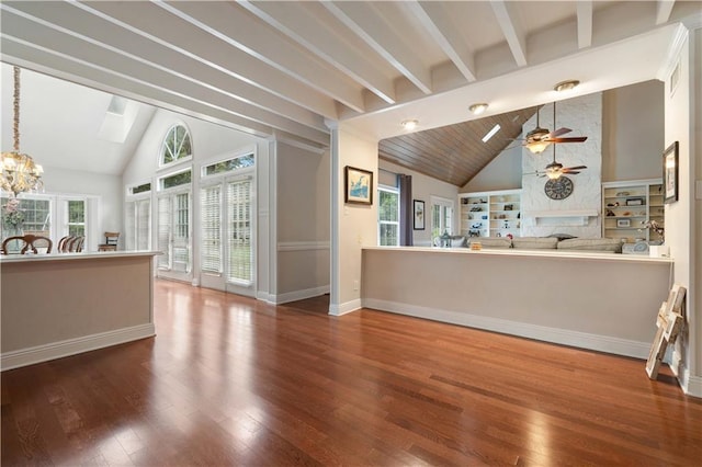 interior space with a large fireplace, beamed ceiling, wood-type flooring, and high vaulted ceiling