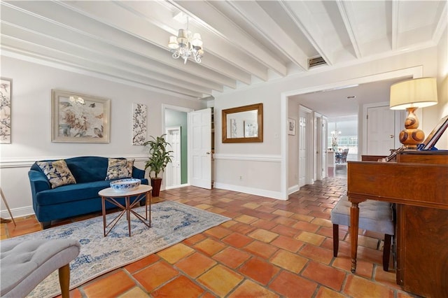 tiled living room featuring beamed ceiling and a chandelier