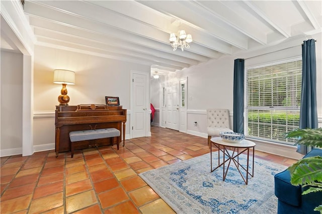 sitting room featuring tile patterned flooring, beam ceiling, and an inviting chandelier