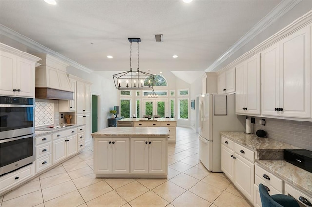 kitchen with double oven, decorative backsplash, a center island, and hanging light fixtures