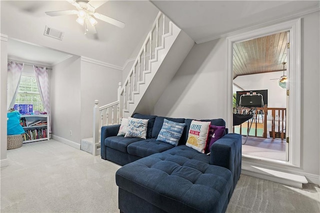 living room featuring ceiling fan, crown molding, and light carpet