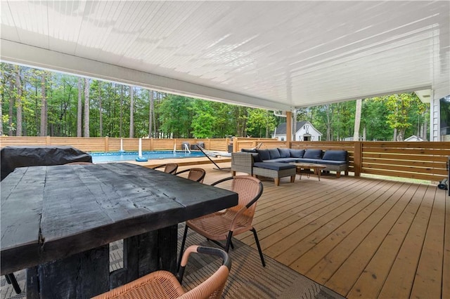 wooden terrace with outdoor lounge area and a fenced in pool