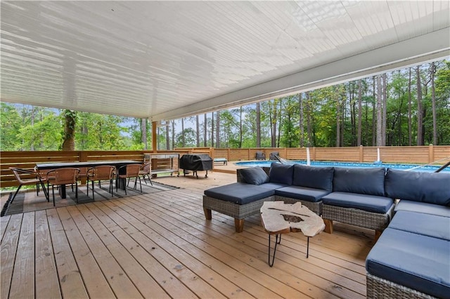 wooden terrace featuring an outdoor living space and area for grilling