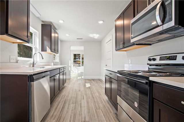 kitchen featuring a sink, dark brown cabinetry, stainless steel appliances, and light countertops