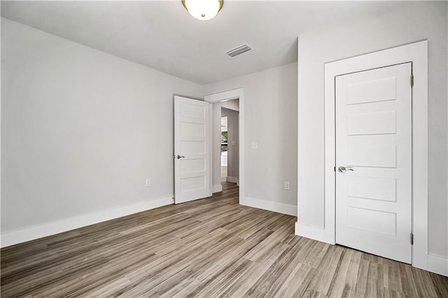 unfurnished bedroom featuring baseboards, visible vents, and light wood-style floors