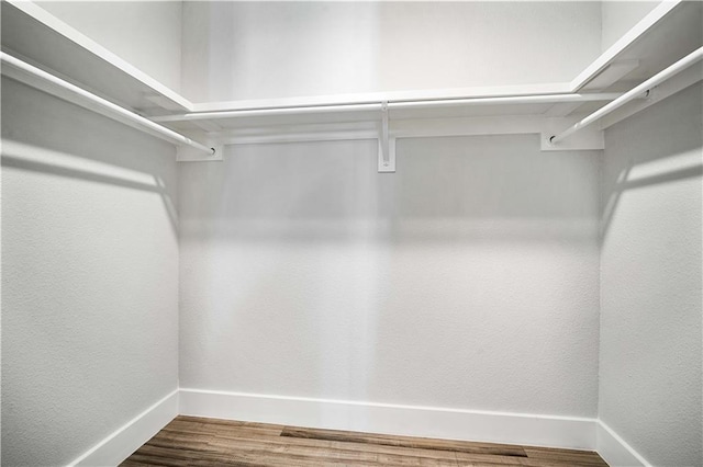 walk in closet with wood finished floors