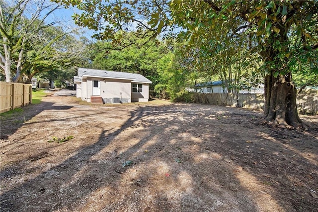 view of yard featuring entry steps and fence