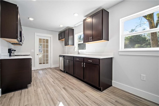 kitchen with dark brown cabinetry, baseboards, stainless steel appliances, light countertops, and light wood-style floors