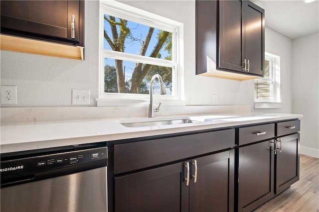 kitchen featuring a sink, dark brown cabinets, light countertops, and stainless steel dishwasher