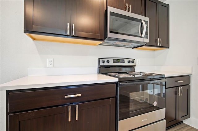 kitchen featuring dark brown cabinets, stainless steel appliances, and light countertops