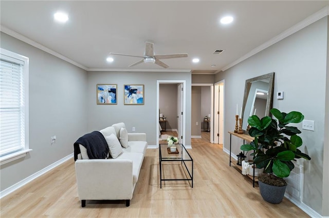 living room with light wood finished floors, baseboards, ceiling fan, and ornamental molding