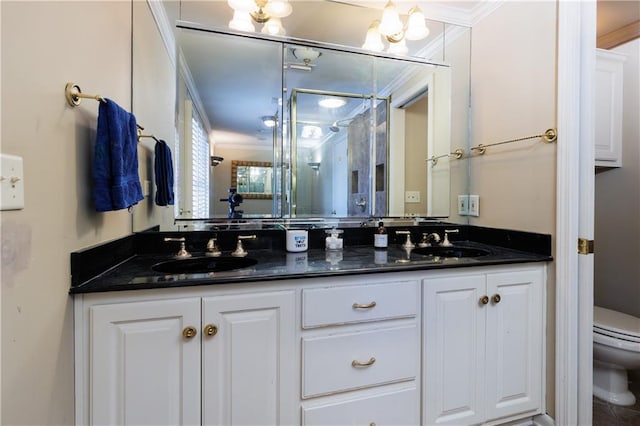 bathroom featuring toilet, vanity, and ornamental molding