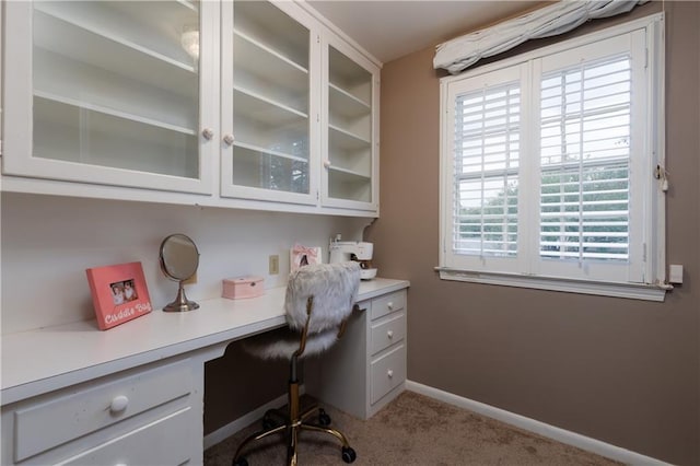 carpeted home office with built in desk