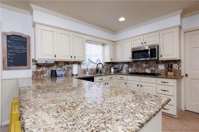 kitchen with light stone countertops, decorative backsplash, black gas stovetop, sink, and light tile patterned floors