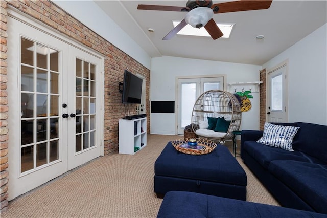 carpeted living room featuring brick wall, lofted ceiling, a wealth of natural light, and french doors