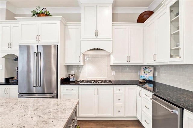 kitchen featuring appliances with stainless steel finishes, white cabinets, and dark stone counters