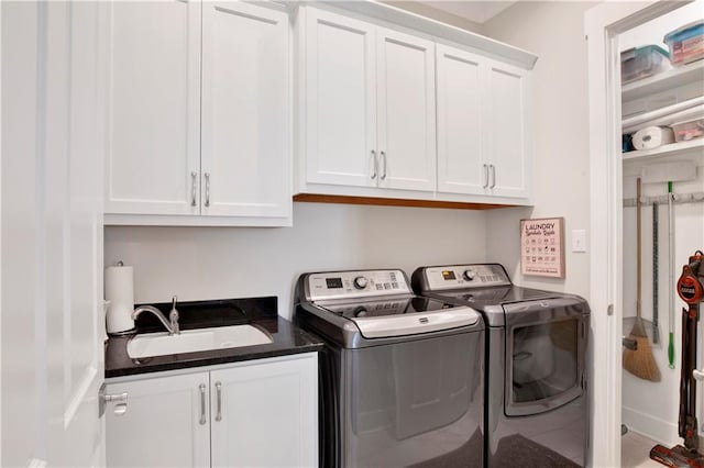 laundry room with sink, washing machine and clothes dryer, and cabinets