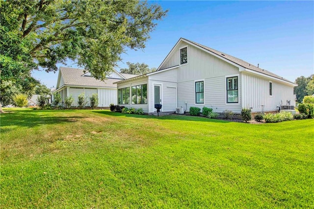 back of property featuring a yard and cooling unit